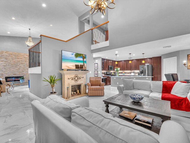 living room featuring a fireplace, sink, and a notable chandelier