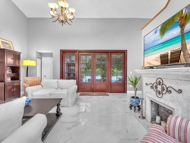 living room with a fireplace, a high ceiling, and a notable chandelier