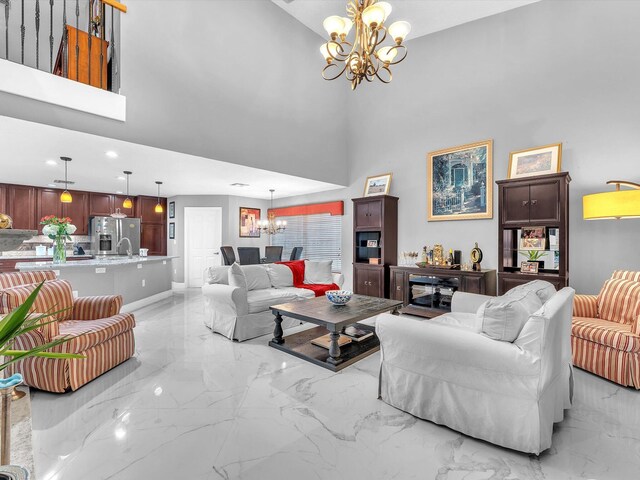 living room with a high ceiling, sink, and a notable chandelier