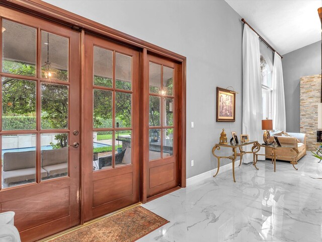 doorway to outside with a wealth of natural light, a high ceiling, and french doors