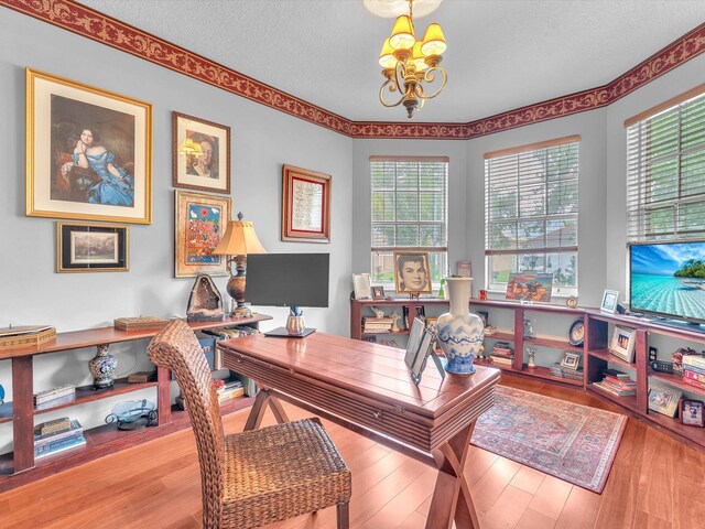 office with hardwood / wood-style flooring, a textured ceiling, and an inviting chandelier