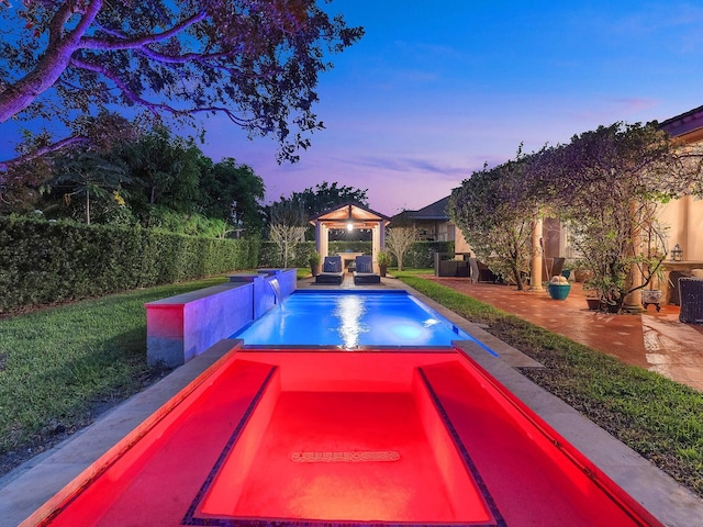 pool at dusk featuring a gazebo