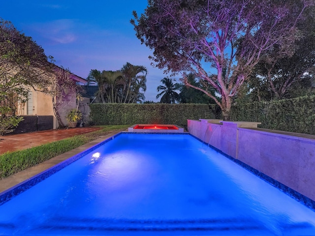 view of pool at dusk