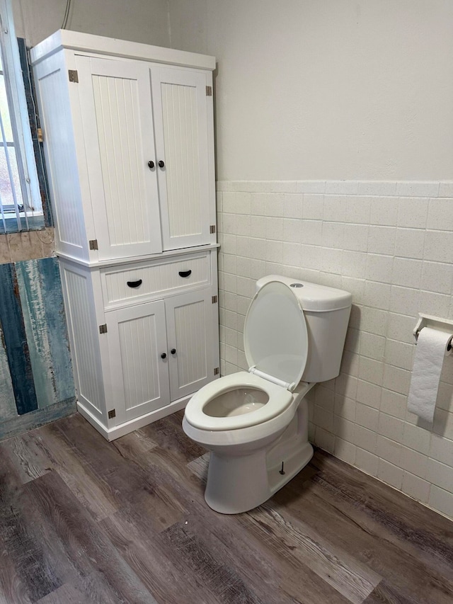 bathroom with tile walls, wood-type flooring, and toilet