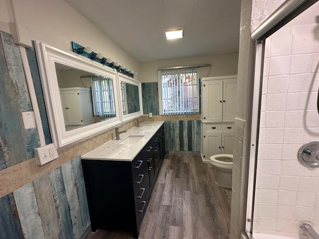 bathroom featuring a shower, toilet, vanity, and hardwood / wood-style floors