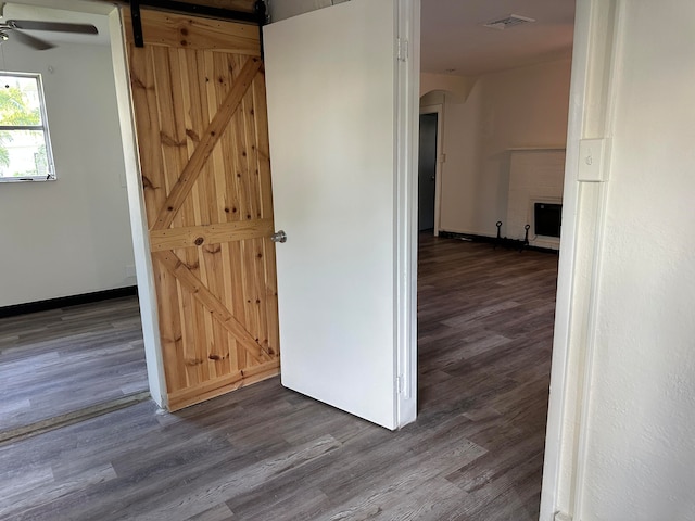 hall featuring a barn door and dark hardwood / wood-style floors