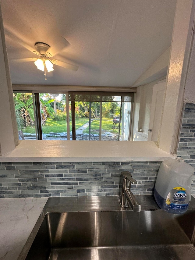 details featuring ceiling fan, tasteful backsplash, and sink