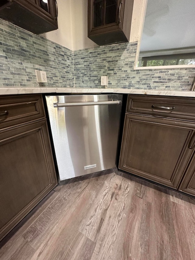 kitchen with tasteful backsplash, dark hardwood / wood-style floors, dark brown cabinetry, and stainless steel dishwasher