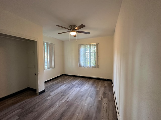 unfurnished bedroom with ceiling fan, a closet, and dark wood-type flooring