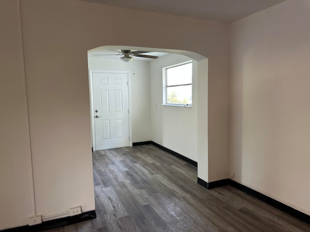 empty room with ceiling fan and dark wood-type flooring