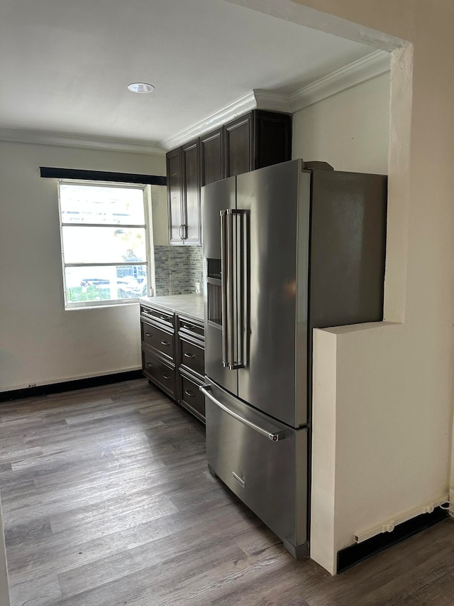 kitchen with high quality fridge, backsplash, light hardwood / wood-style floors, and ornamental molding