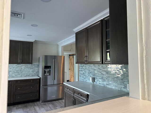 kitchen with ornamental molding, high quality fridge, hardwood / wood-style floors, and dark brown cabinetry