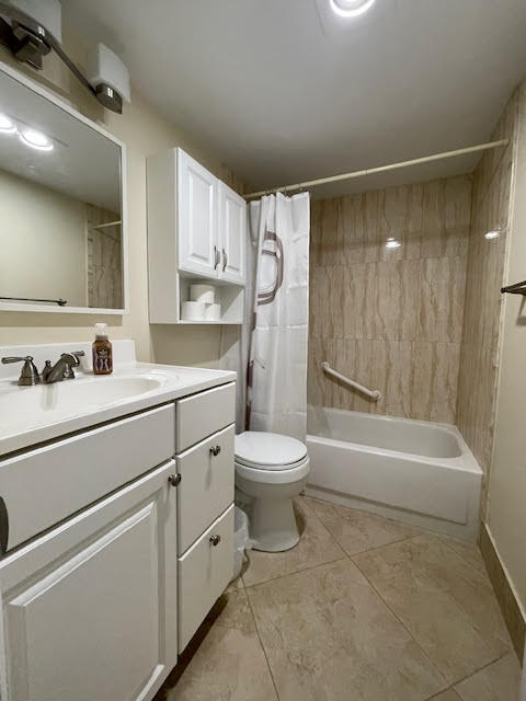 full bathroom with vanity, shower / tub combo with curtain, and toilet