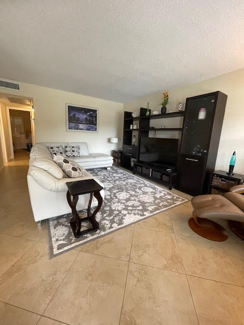 living room featuring a textured ceiling and tile patterned floors