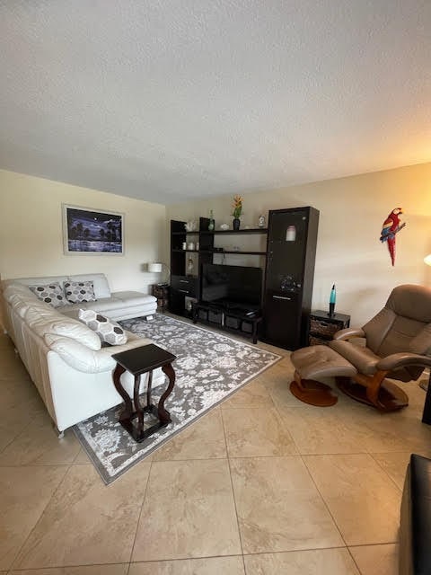 living room featuring a textured ceiling and light tile patterned floors