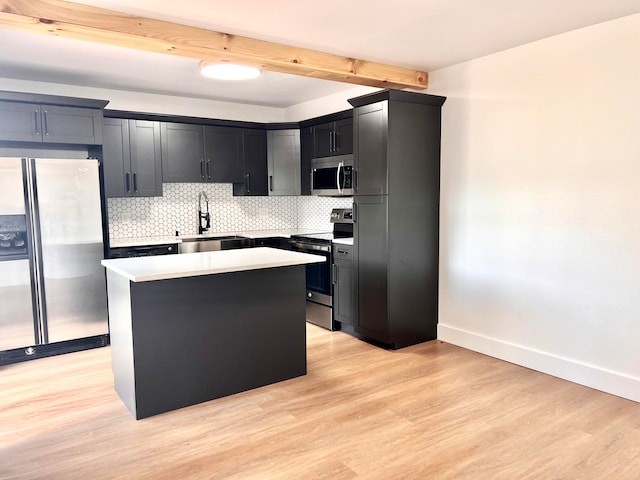 kitchen with stainless steel appliances, light hardwood / wood-style floors, a kitchen island, and sink