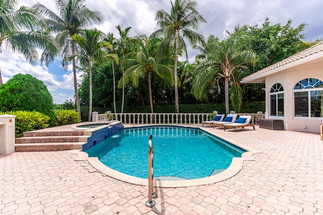 view of swimming pool featuring a patio and an in ground hot tub