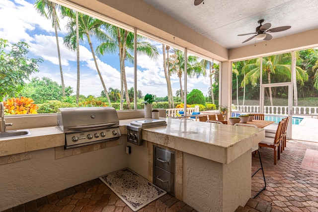 view of patio with ceiling fan, area for grilling, and grilling area