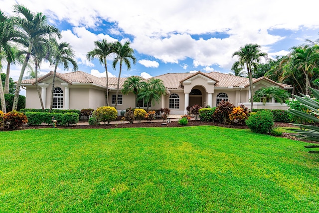 15495 Tall Oak Ave, Delray Beach, FL 33446 - mediterranean / spanish-style home featuring a front yard, stucco siding, and a tiled roof
