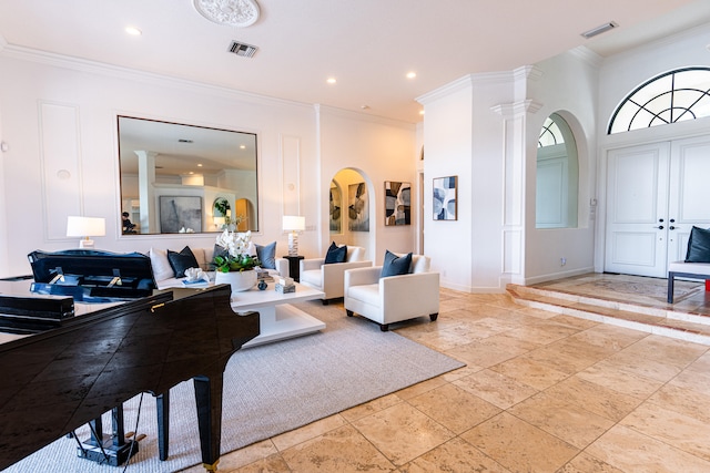 living room with crown molding and ornate columns