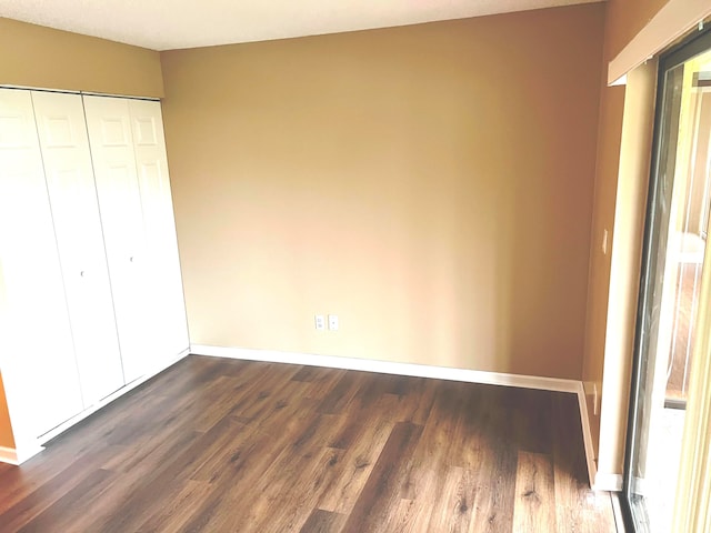 unfurnished bedroom featuring dark wood-type flooring and a closet