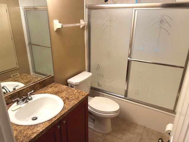 full bathroom featuring shower / bath combination with glass door, tile patterned flooring, vanity, and toilet