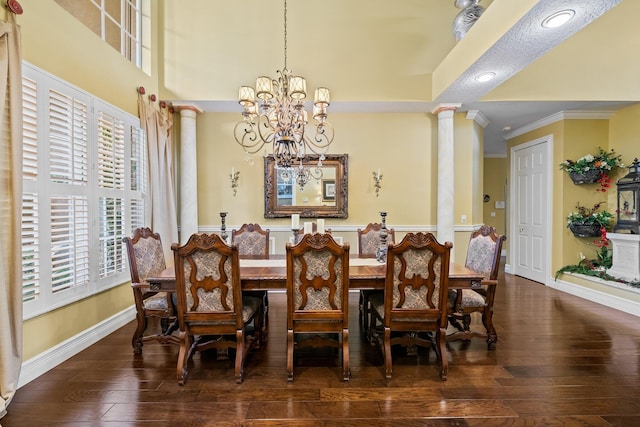 dining space with ornamental molding, an inviting chandelier, wood-type flooring, and ornate columns