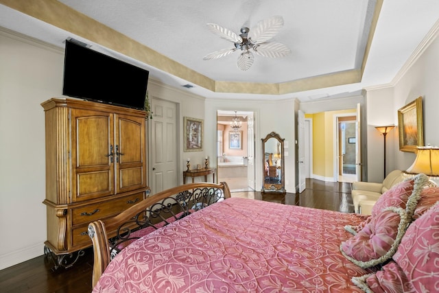 bedroom with dark wood-type flooring, ensuite bathroom, a raised ceiling, crown molding, and ceiling fan with notable chandelier