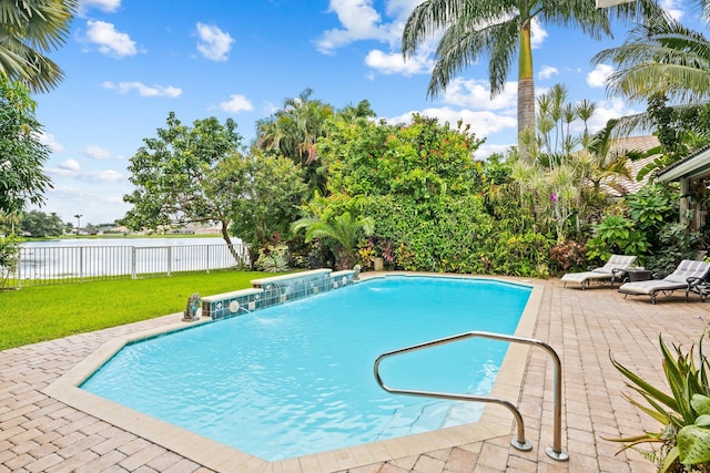 view of swimming pool with pool water feature, a yard, and a patio area