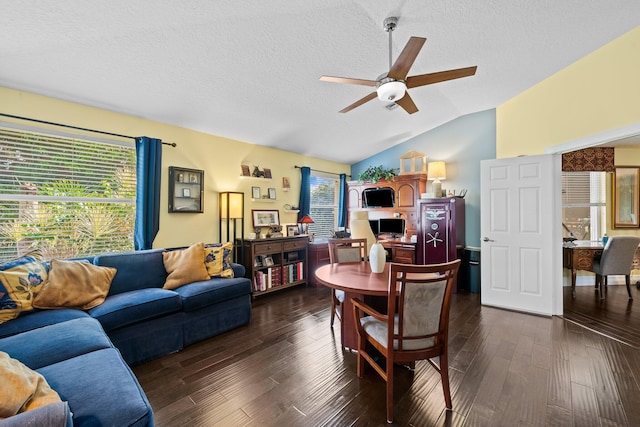 dining room with a textured ceiling, ceiling fan, vaulted ceiling, and dark hardwood / wood-style floors