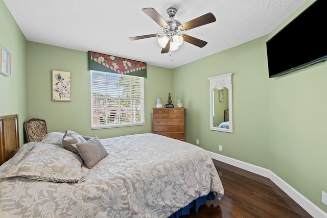 bedroom with a textured ceiling, ceiling fan, and dark hardwood / wood-style floors