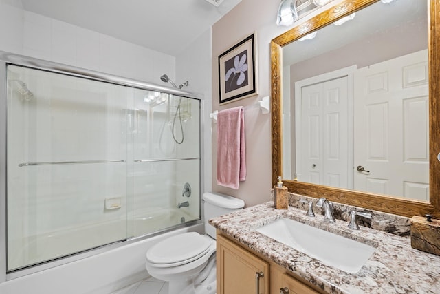 full bathroom featuring enclosed tub / shower combo, tile patterned floors, vanity, and toilet