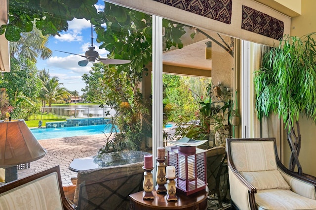 exterior space with pool water feature, ceiling fan, a fenced in pool, and a water view