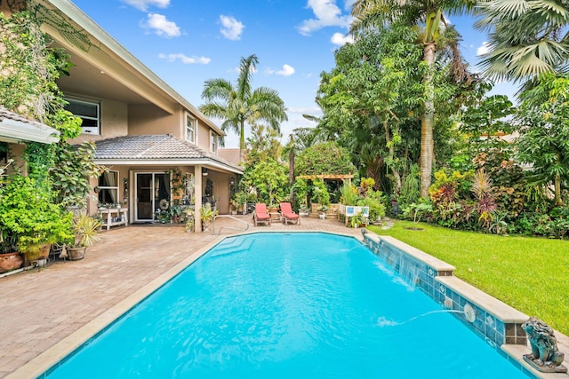 view of pool featuring a yard, pool water feature, and a patio