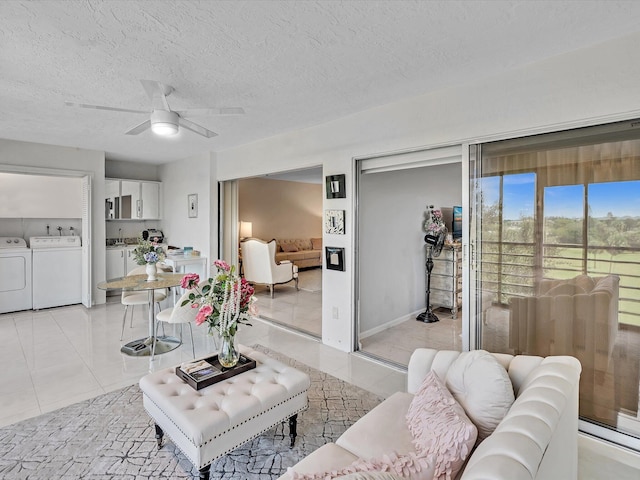 living room with washer and dryer, ceiling fan, light tile patterned flooring, and a textured ceiling