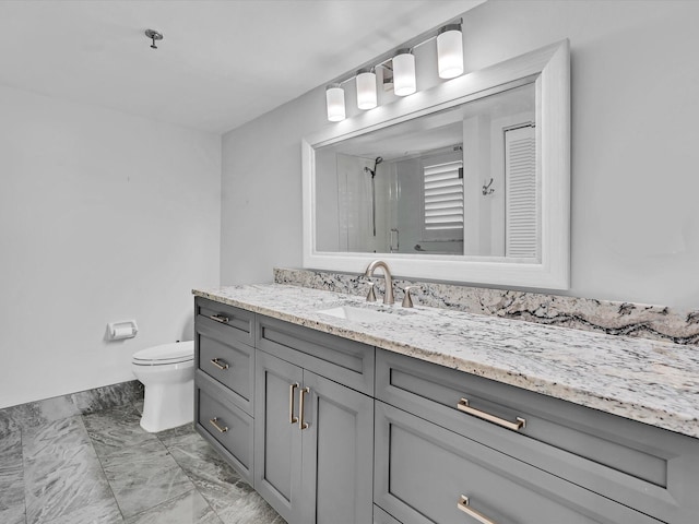 bathroom featuring vanity, a shower with shower door, and toilet