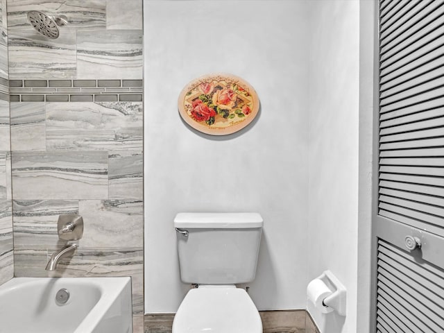 bathroom featuring hardwood / wood-style floors, tiled shower / bath combo, and toilet