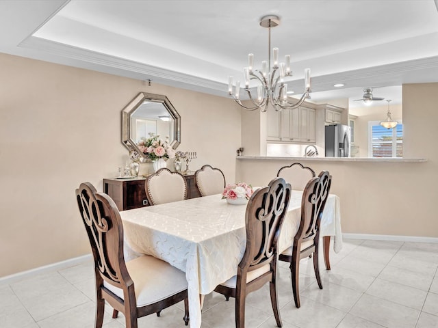 tiled dining area with ceiling fan with notable chandelier and a raised ceiling