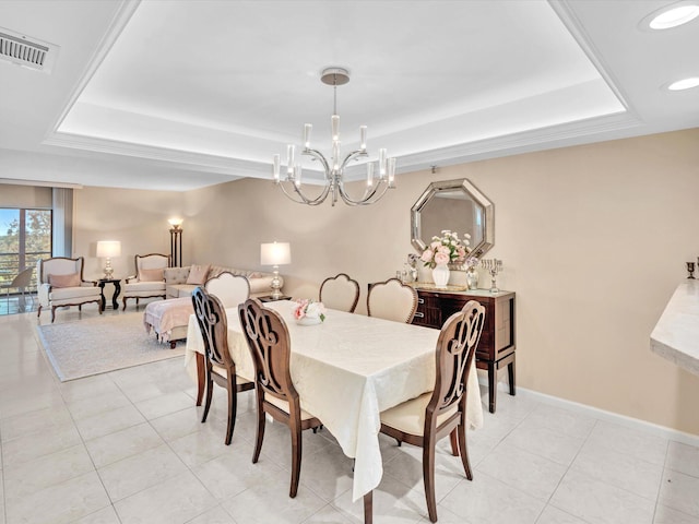 tiled dining space with a tray ceiling and a chandelier