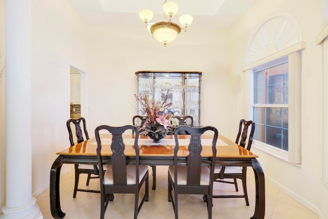 dining area with ornate columns, light tile patterned floors, and a chandelier