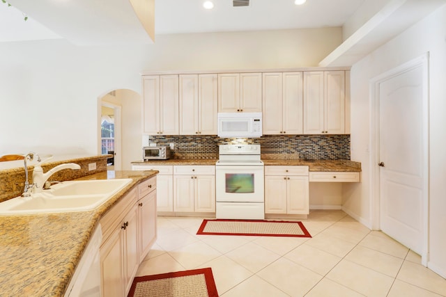 kitchen featuring white appliances, cream cabinetry, light tile patterned flooring, and sink