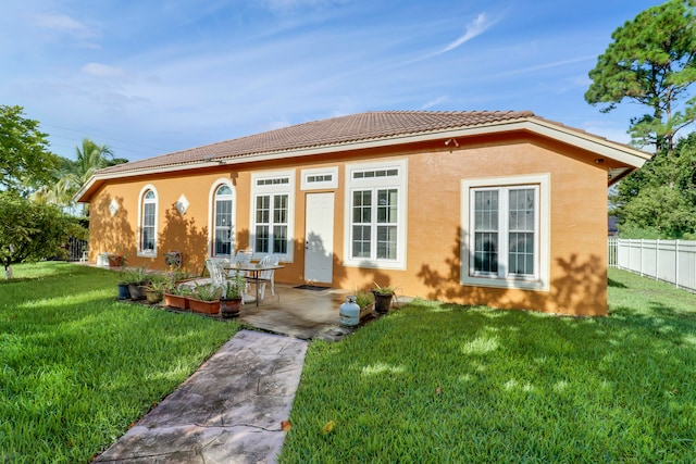 mediterranean / spanish house featuring a front yard and a patio area