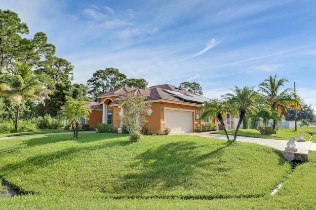 mediterranean / spanish-style house featuring a front yard, a garage, and solar panels