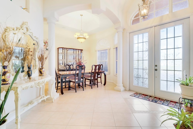 entryway with decorative columns, an inviting chandelier, light tile patterned floors, and french doors