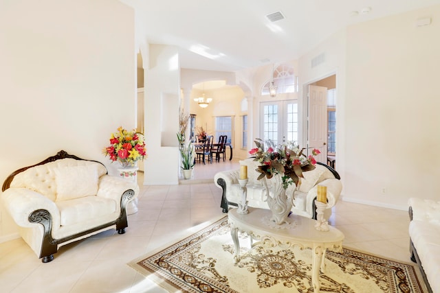 living room with light tile patterned floors, french doors, and a chandelier