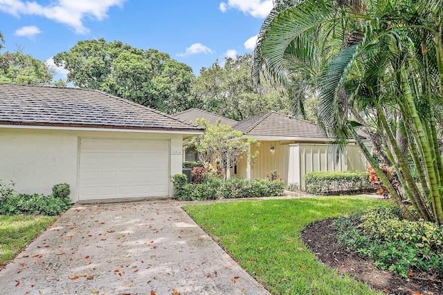 view of front of home featuring a garage and a front lawn