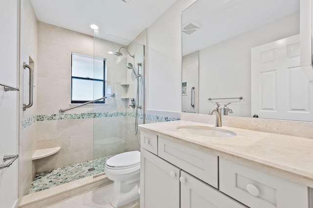 bathroom featuring a shower with shower door, vanity, and toilet