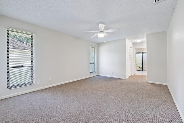 spare room featuring ceiling fan, a textured ceiling, and light carpet