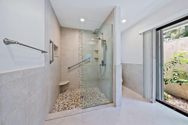 bathroom featuring tile walls, a shower with door, and tile patterned floors