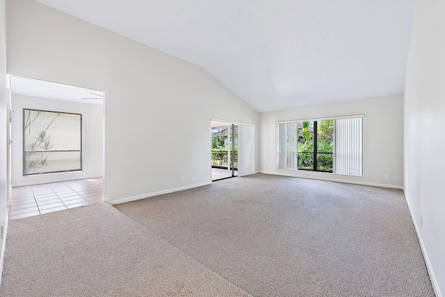 unfurnished room with lofted ceiling and light carpet